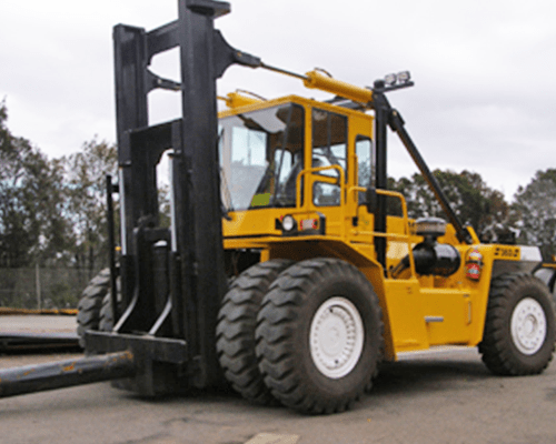 A person operating a JCB digger in the outdoors.